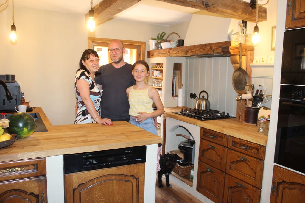 Sylvia Sordel, Sven Johanson und Luise stehen in der frisch restaurierten Küche ihres nachhaltig sanierten Fachwerkhauses.