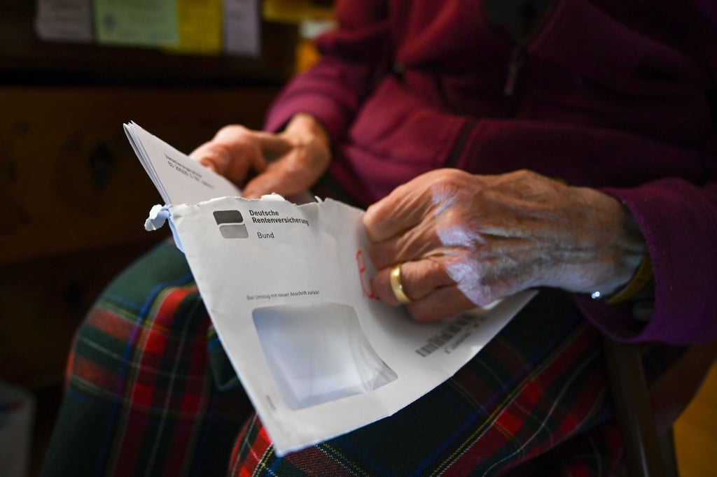 Eine Seniorin hält ihren Rentenbescheid in der Hand.