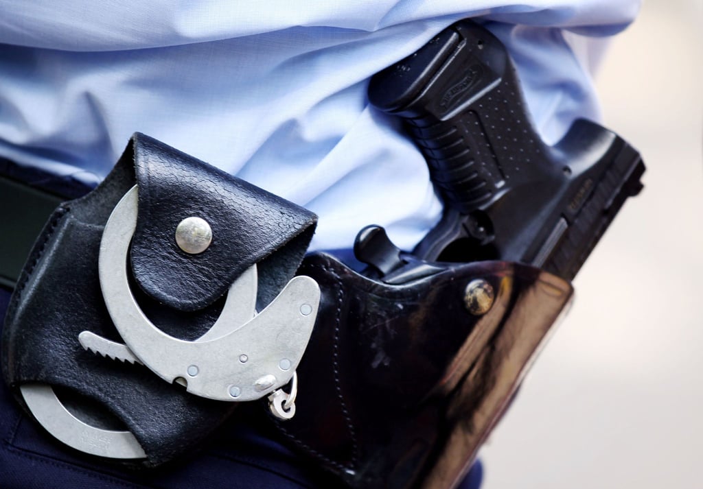 Ein Polizist mit Handschellen und Pistole am Gürtel.