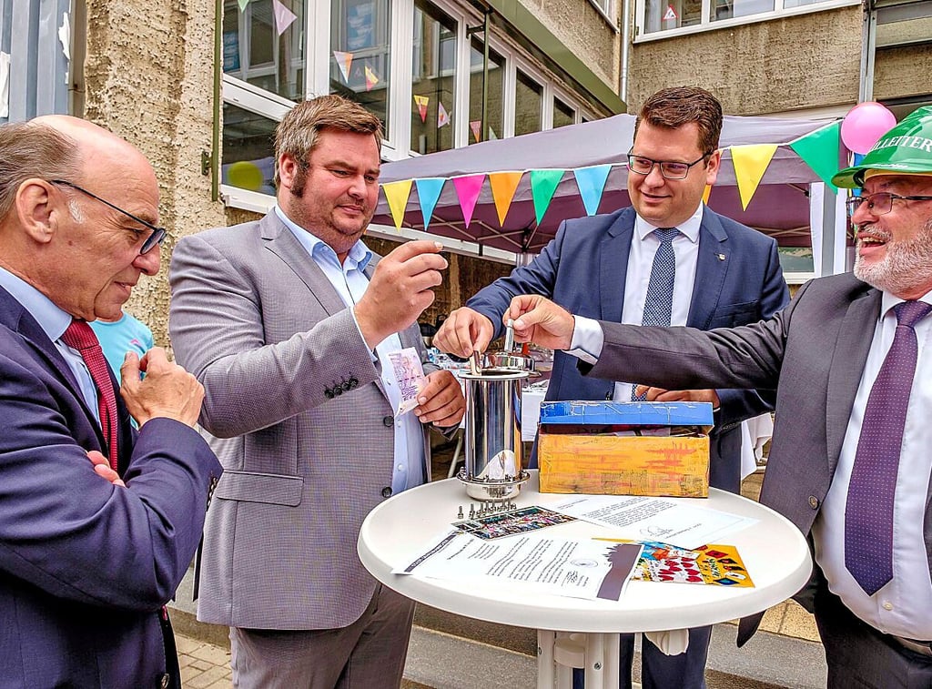 Stück für Stück wird die Kapsel gefüllt: Eine 20-Euro-Münze mit der Maus kommt vom Kreis, ein Null-Euro-Schein mit Ferropolis von der Stadt.
