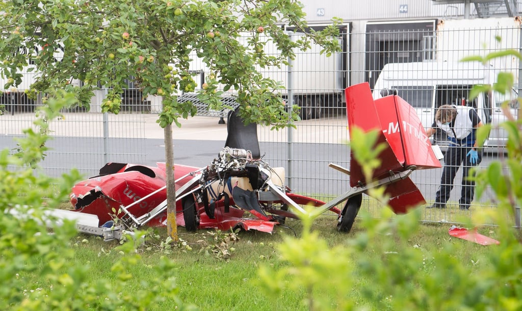 Ein zerstörter Tragschrauber liegt nach einem Absturz am Zaun eines Logistikzentrums.
