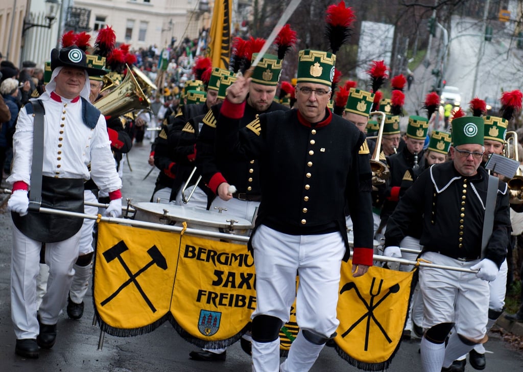 Teilnehmer der Bergparade in Freiberg (Sachsen) gehen in historischer Bergarbeiterkleidung durch die Altstadt.