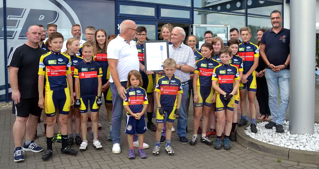 Eingerahmt von Nachwuchssportlern des Radsportvereins Osterweddingen übergibt der Vizepräsident Leistungssport beim Kreissportbund Börde, Knut Förster (l.), die Ernennungsurkunde an den Vorsitzenden des Radsportvereins Osterweddingen, Siegfried Kindler.