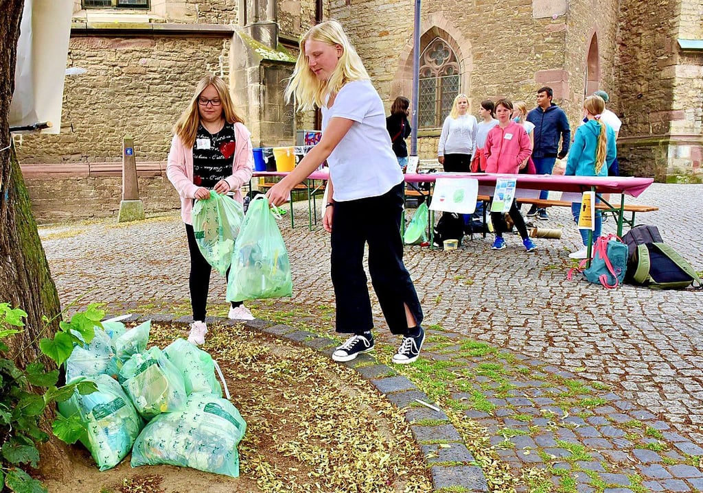 Die Klasse 6/3 des Humboldtgymnasiums hat in Hettstedt Müll gesammelt: So wie Lena und Amelie (v.li.), die am Projekt teilgenommen haben und die nächsten der insgesamt 23 Müllsäcke demonstrativ auf dem Markt stapeln.