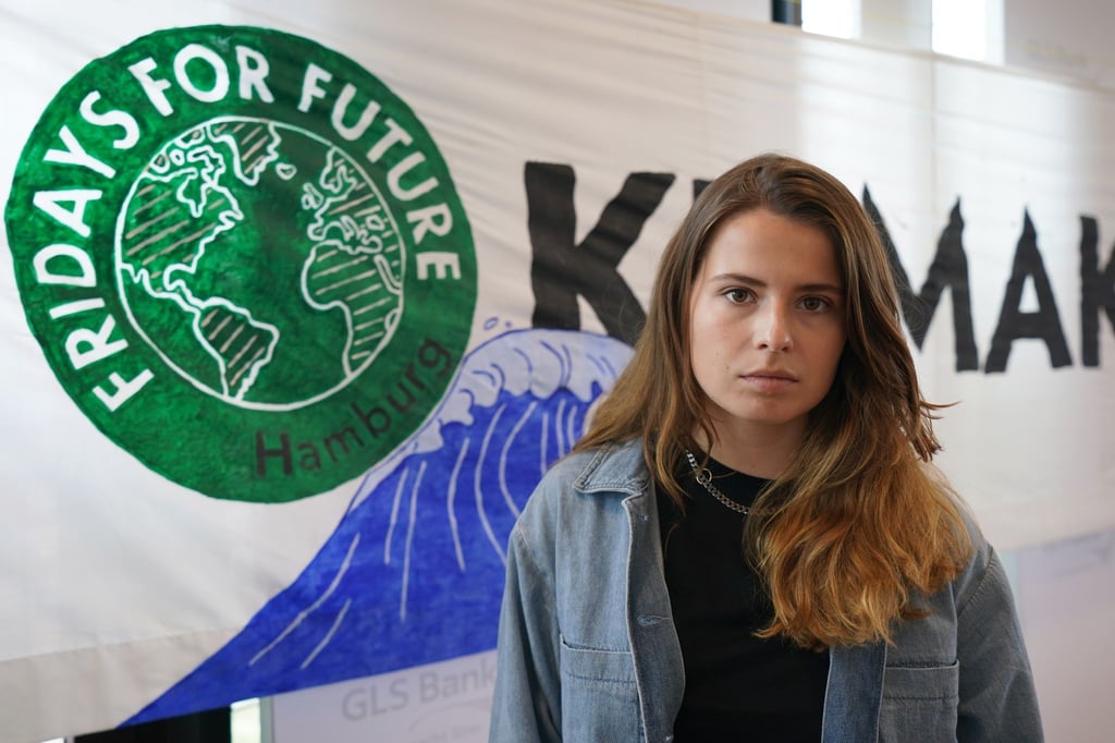 Klimaaktivistin Luisa Neubauer steht nach einer Pressekonferenz des Bündnisses Fridays for Future vor dem Logo des Bündnisses.