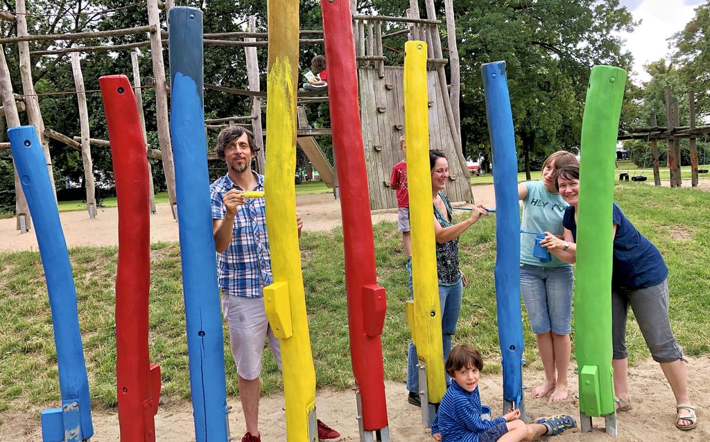Mitglieder der Spielplatzinitiative geben den Holzelementen im Pollingpark neue Farbe.
