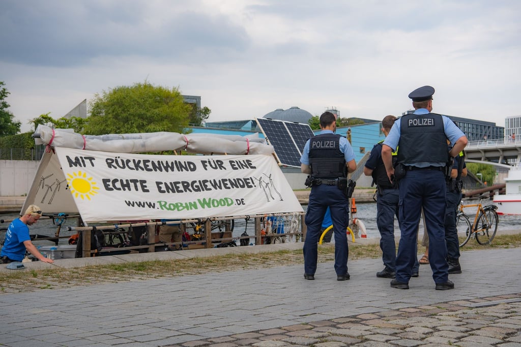 Polizeibeamte stehen im Regierungsviertel an einem Floss der Umweltschutzorganisation Robin Wood.