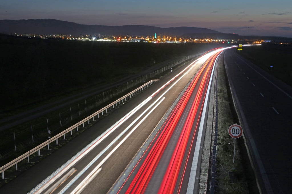 Scheinwerfer vorbeifahrender Fahrzeuge ziehen auf der Autobahn A36 bei Wernigerode Lichtspuren.
