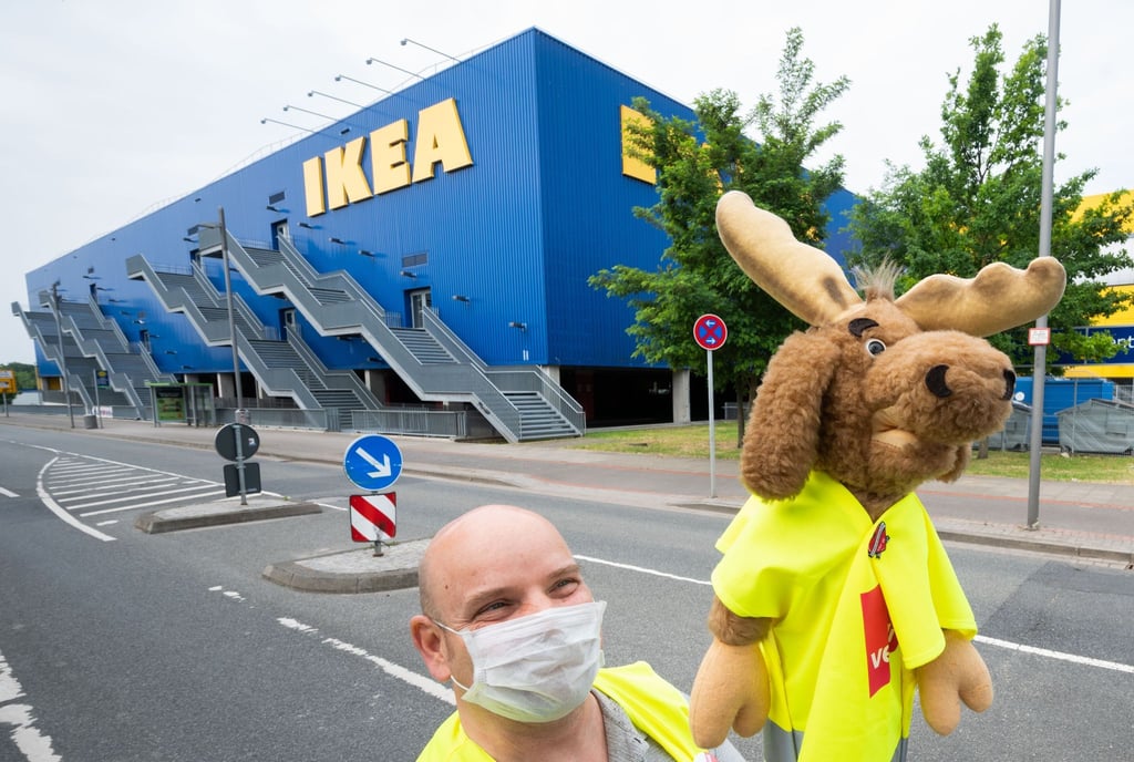 Ein Beschäftigter der Möbelhauskette Ikea steht mit einem Stoffelch bei einem Streik vor der Ikea-Filiale am Expopark in Laatzen.