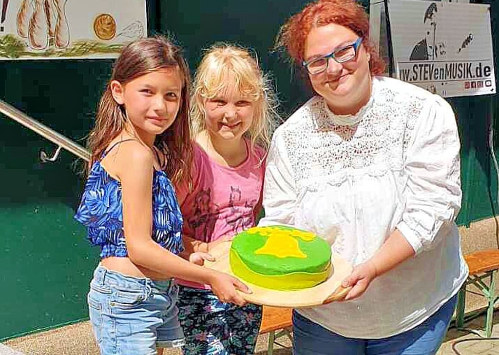 Luisa Martini und ihreTochter Ronja (MItte) sowie Lina Brune präsentieren eine Torte mit dem Wappen von Klüden.