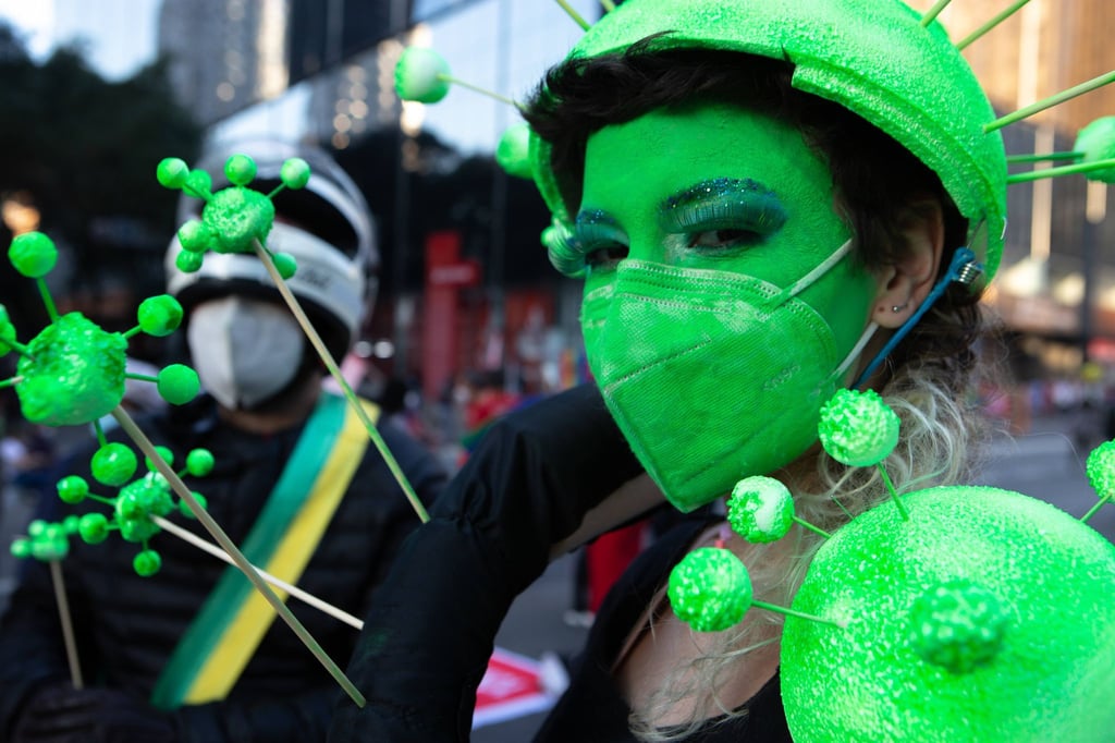 Ein Demonstrantin hat sich ihr Gesicht grün geschminkt und trägt eine grüne Schutzmaske. Tausende Brasilianer sind erneut gegen die Corona-Politik der Regierung von Bolsonaro auf die Straße gegangen.