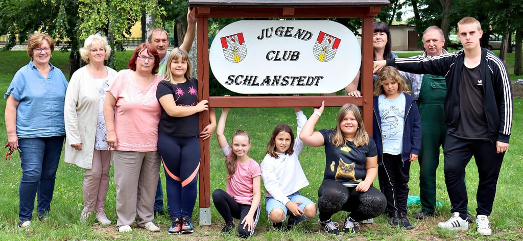 Der Jugendclub Schlanstedt ist nun nicht mehr zu verfehlen. Das neue Schild wurde von den Mitarbeitern des Aus- und Weiterbildungszentrums Halberstadt (AWZ) aufgestellt, von links: Petra Schäftner, Waltraud Beck, Dagmar Jost, Peter Hoffmeister, Lea, Lia, Annabell, Lena und Pauline, dahinter: Christine Götze, Joachim Meitzner und Justin Kosinski.