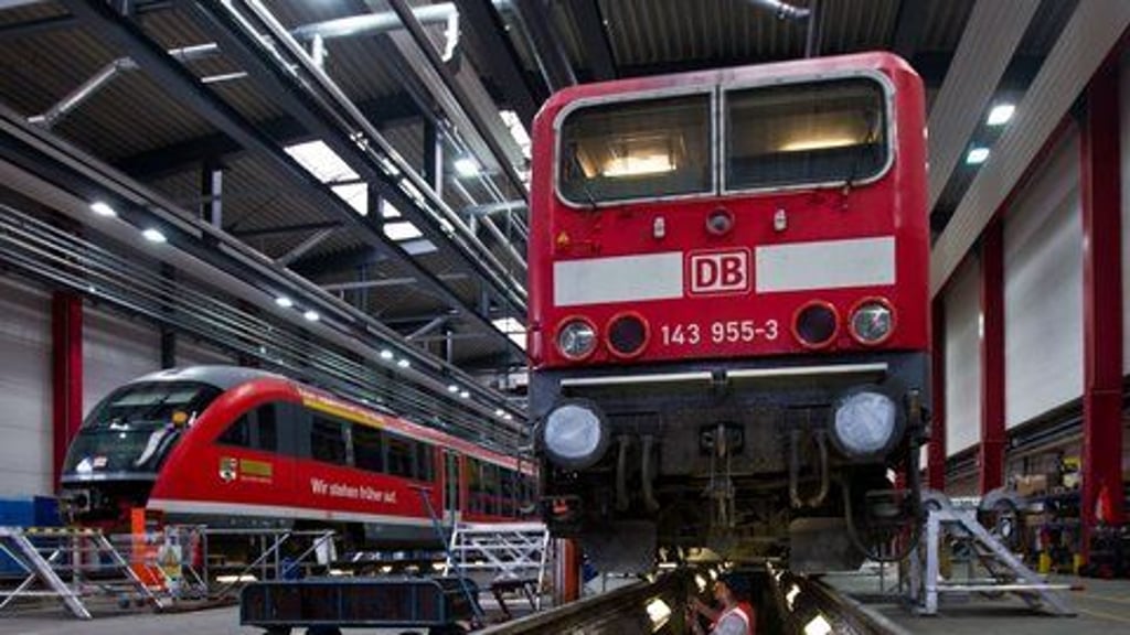 Eine Elektrolokomotive der Baureihe 143 wird in einer Bahn-Werkstatt gewartet.