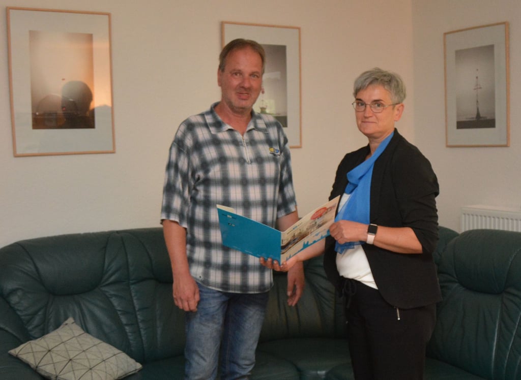 Wobau-Chefin Bärbel Michael überreicht Andreas Randau zum Einzug eine Info-Mappe über Kulturveranstaltungen in Burg.