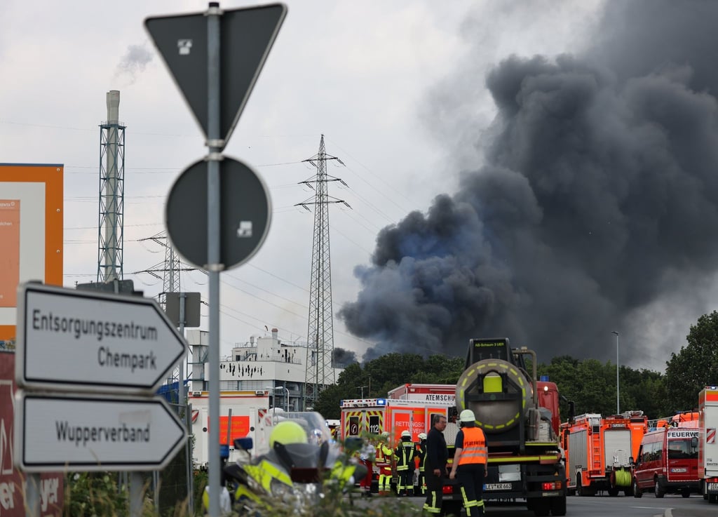 Einsatzfahrzeuge der Feuerwehr stehen unweit der Zufahrt zum Chempark Leverkusen.