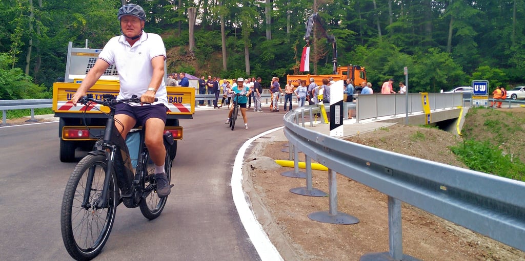 Werner und Regina Priesterjahn aus Heimburg sind die ersten Verkehrsteilnehmer, die bei einer Fahrradtour die neue Brücke über den Teufelsbach zwischen Heimburg und queren.
