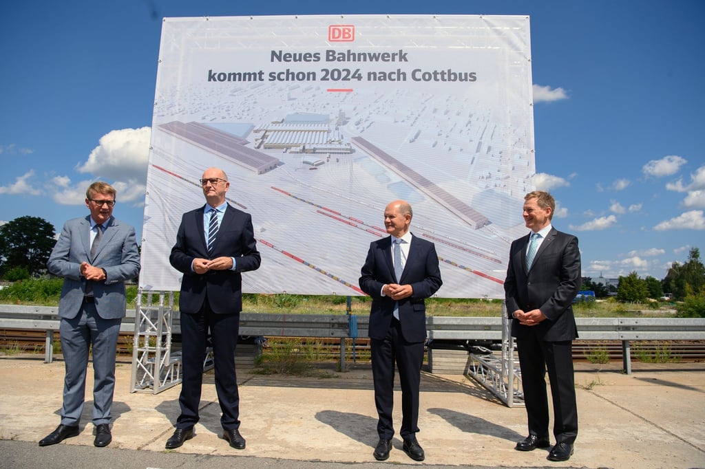Vorstellung der Pläne zum neuen ICE-Instandhaltungswerk vor einem Plakat mit der Aufschrift „Neues Bahnwerk kommt schon 2024 nach Cottbus“.