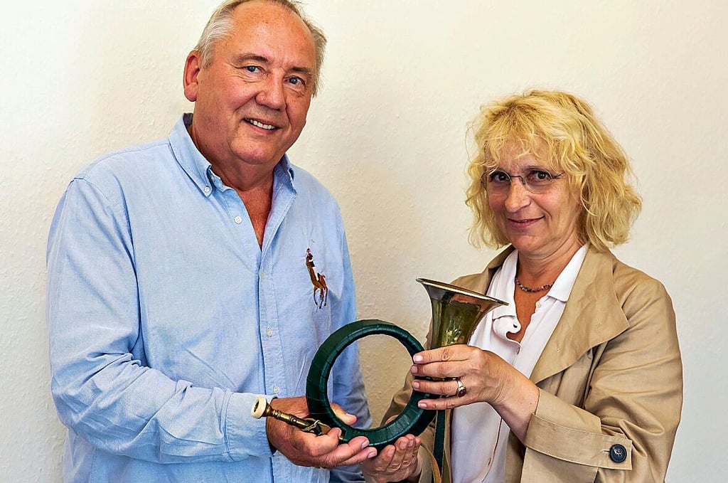 Heinrich Meyer übergibt das Jagdhorn mit der Gravur „Fürst Pless“ an KKM-Geschäftsführerin Christine Friedrich.