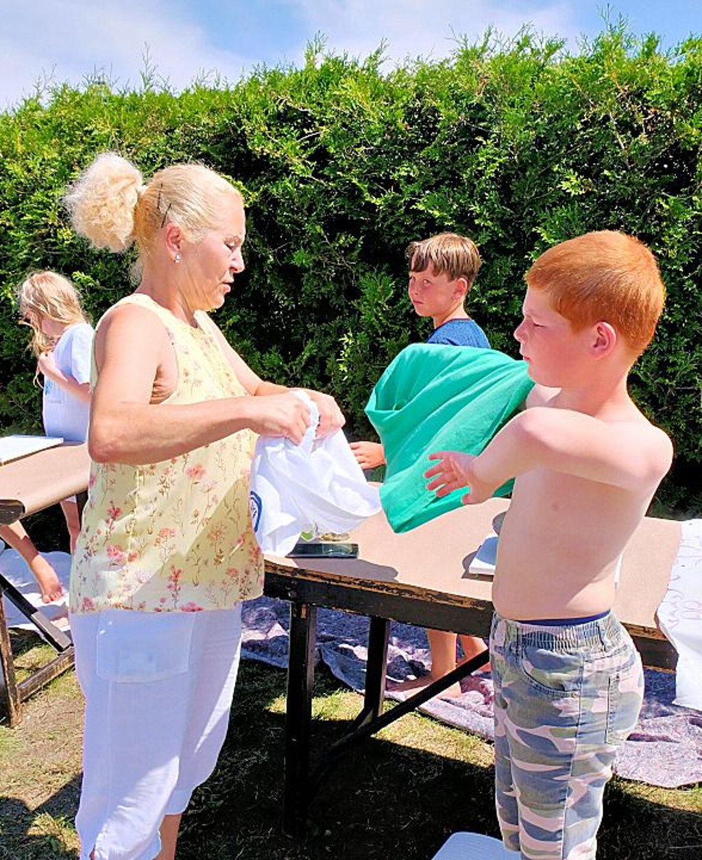 Jugendclub-Chefin Sabine Hoffmann hilft beim Shirtwechsel.