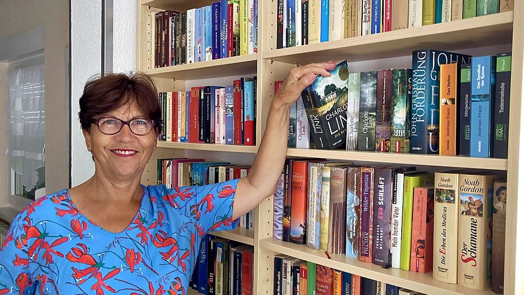 Barbara Jokl zeigt den Bücherfundus, der ab Montag im Vereinsheim des Siedlervereins „Fuchsbreite“ im Libellenweg 10 im Magdeburger Stadtteil Hopfengarten für Interessierte zugänglich ist.