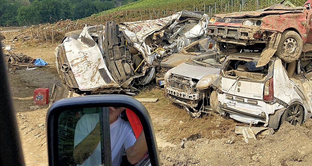 In Marienthal sind zerstörte Autos am Ortsrand aufgestapelt. Im Rückspiegel: Helfer Marcel Gabriel aus Salzwedel.