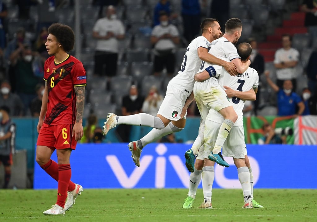 Während Italiens Spieler in München den Halbfinal-Einzug feiern, schaut Belgiens Axel Witsel (l) enttäuscht drein.