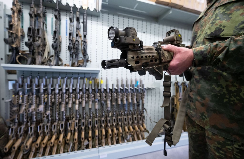Ein spezielles Modell des G36 Sturmgewehrs von Heckler & Koch zeigt ein Soldat der Bundeswehr in einer Waffenkammer. Im Streit um einen Sturmgewehr-Großauftrag gerät das Beschaffungsamt der Bundeswehr in das Visier von Kritikern.