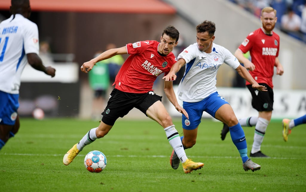 Hannovers Sebastian Stolze (l) und Rostocks Lukas Scherff kämpfen um den Ball.