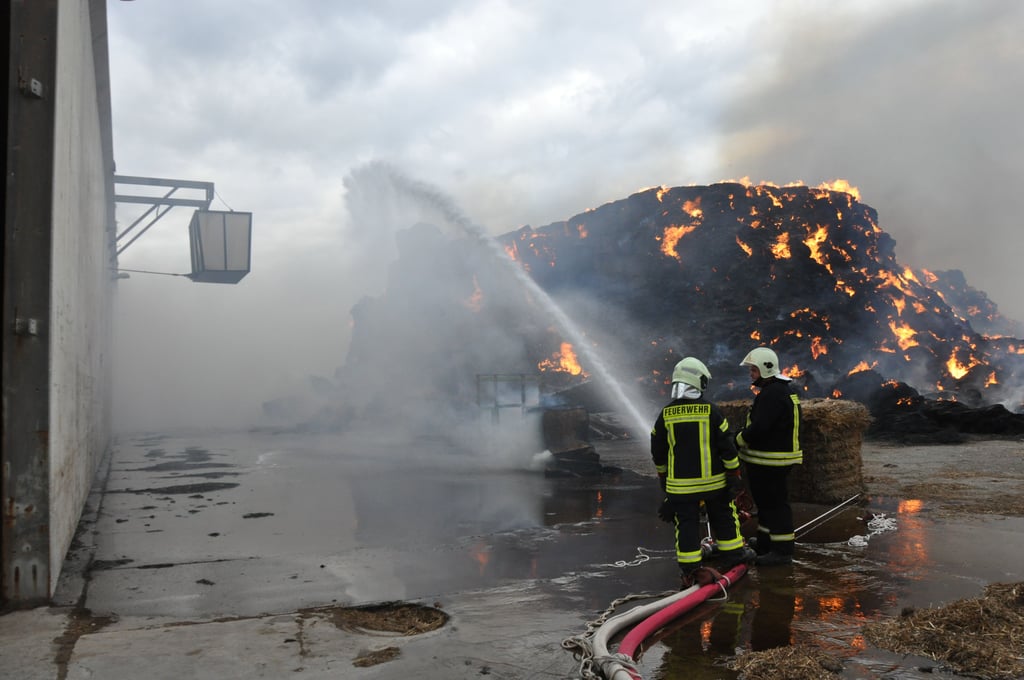 Aufgabe der Kameraden ist es in erster Linie, mit sogenannten Riegelstellungen, also mit einem Wasservorhang, die Produktionsanlagen vor der Hitze der abbrennenden Strohdiemen zu schützen.