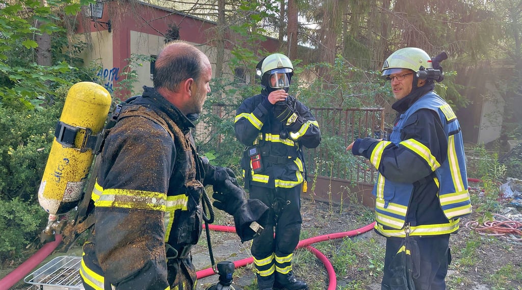 Kurze Besprechungen zwischen Gruppenführer und Kameraden, die am Donnerstagabend in Halberstadt das Feuer am ehemaligen Jugendklub Salut löschten. Ein böser Vorfall überschattet den Einsatz.