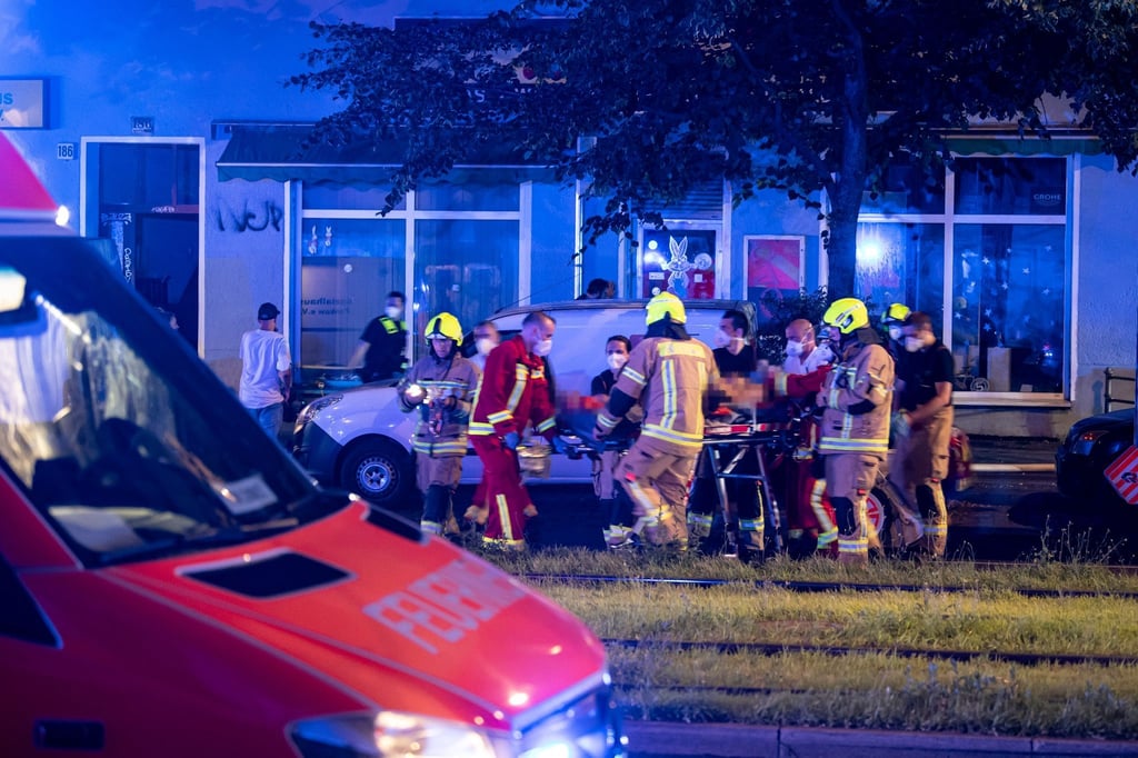 Ein Verletzter wird mit einer Trage zum Krankenwagen transportiert.
