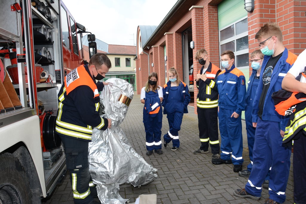 Zum ersten Mal nach gut eineinhalbjähriger Corona-Pause konnte wieder eine Ausbildung für die Klötzer Jugendfeuerwehr stattfinden. Der stellvertretende Jugendwart Florian Paul stellte den Hitzeschutzanzug vor, der im Einsatzfahrzeug bereitliegt.