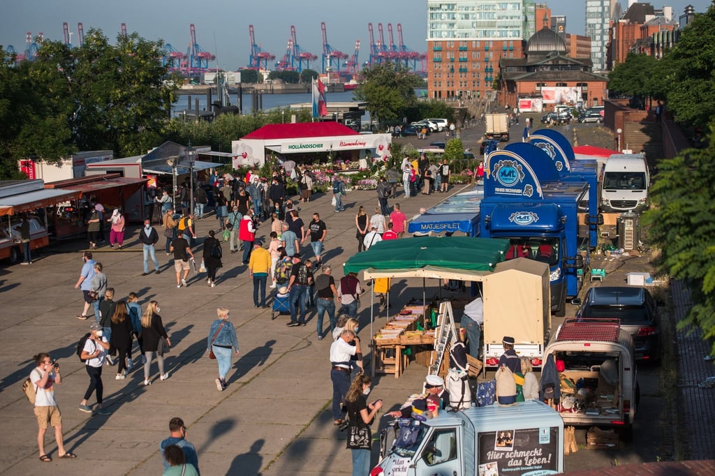 Besucher gehen über den Hamburger Fischmarkt.