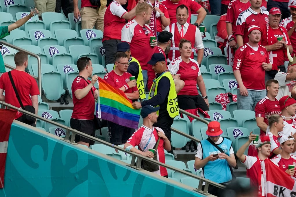 Ordner nehmen zwei Dänemark Fans eine Regenbogen-Fahne ab.
