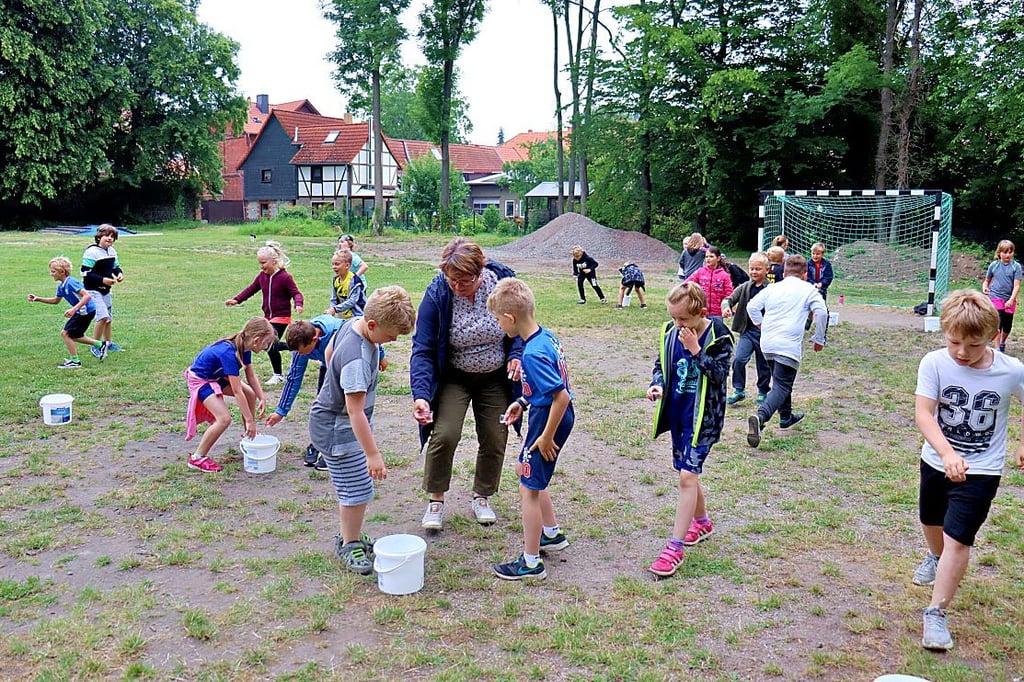 Hier muss Wasser per Schnapsglas transportiert werden, Lehrerin Rosita Steiner macht mit, weil zur Gruppe „Lenny" ein Kind weniger gehört.
