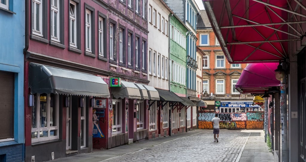 Ein Mann geht durch die menschenleere Herbertstraße.