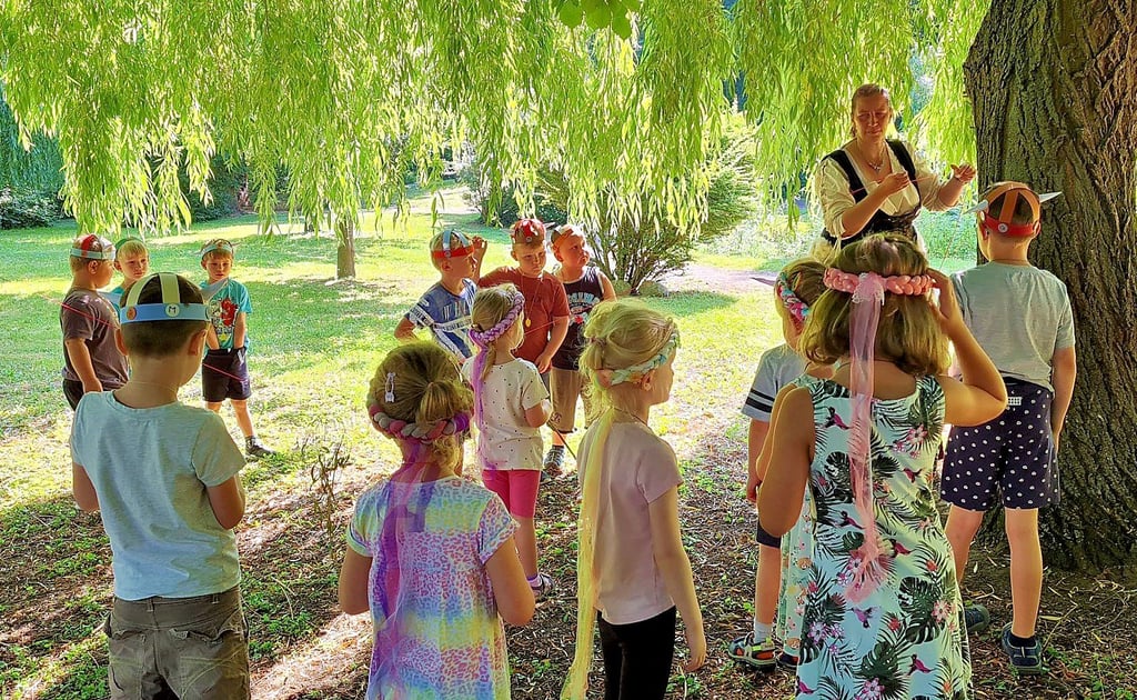 Schatzsuche: Nancy Brockholz zeigt den Abc-Schützen der „Wilden Schwäne“, was der Baum ihnen auf ihrer Wikinger-Tour für einen Tipp geben kann.