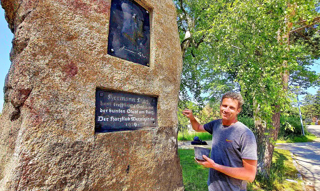 Restaurator Tom Zimmermann hat wahrscheinlich gerade den schönsten Arbeitsplatz der Stadt. Hoch über Wernigerode auf dem Blockshornberg verschönert er das Hermann-Löns-Denkmal. Löns prägte einst Wernigerodes Beinamen „Die bunte Stadt am Harz“.