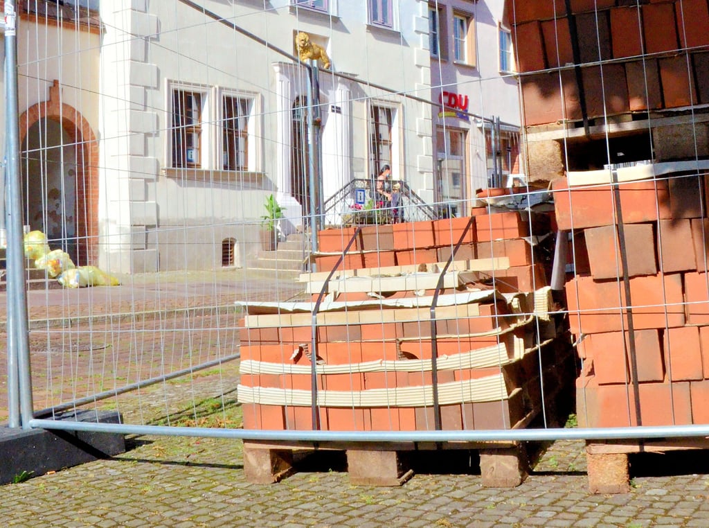 Die ersten Baumaterialien sind schon angeliefert worden. Direkt neben dem Rathaus mussten sie allerdings hinter Gitter, um Diebstahl vorzubeugen.