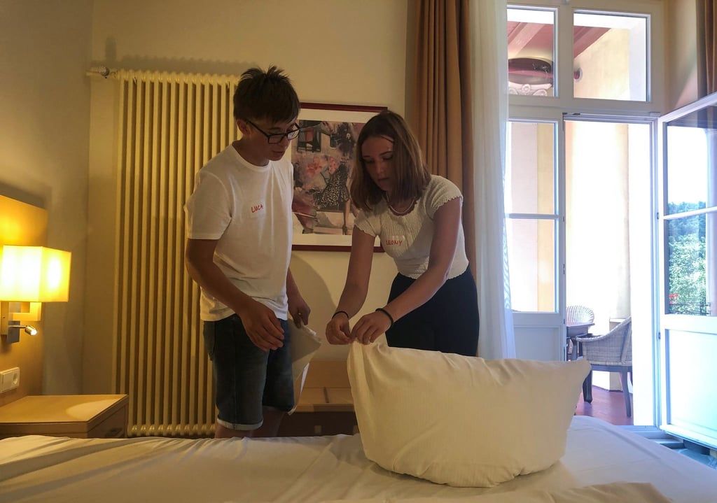 Luca Neubüser (l) und Leony Müller üben sich im Parkhotel Bad Schandau im Bettenmachen.