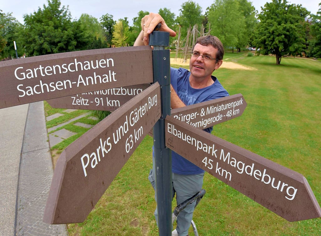 Aka-Gartenchef Lars Heidenreich befestigt die neuen Schilder auf der Herrenbreite.