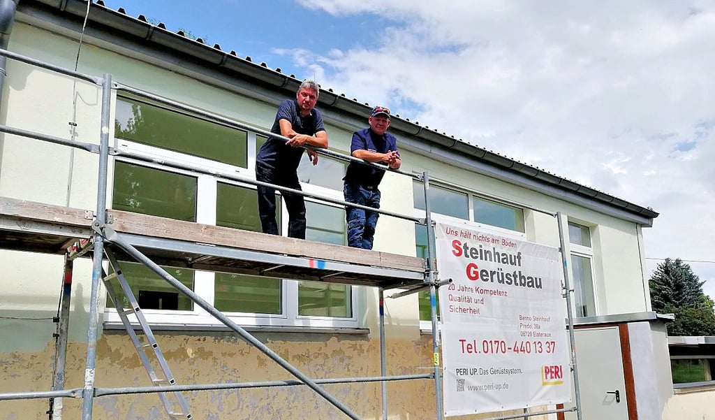 Jens Keinitz und Henry Steinhauf stehen gemeinsam auf dem Gerüst am ehemaligen Kulturzentrum in Profen.