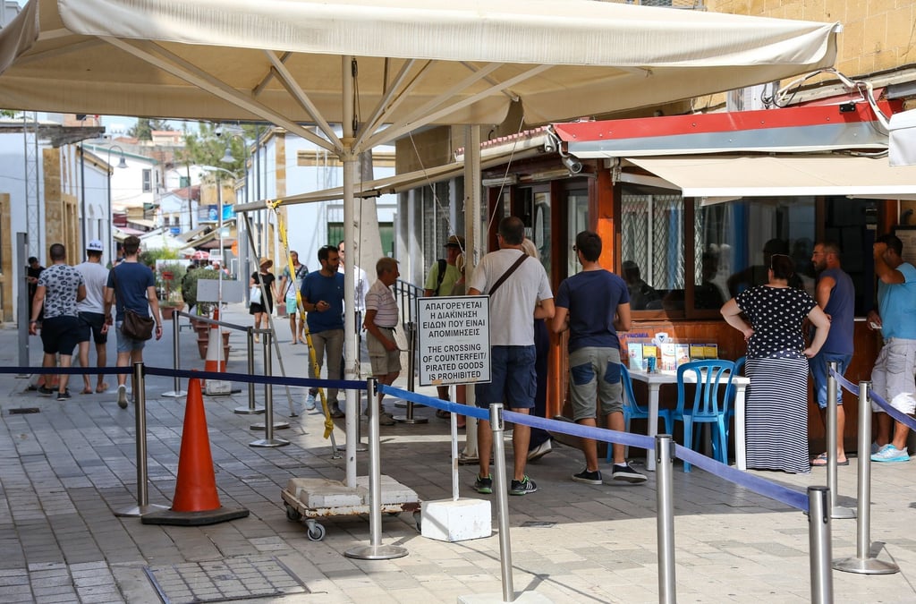 Menschen stehen in Zyperns Hauptstadt Nikosia am Grenzübergang zum türkischen Teil der Stadt.
