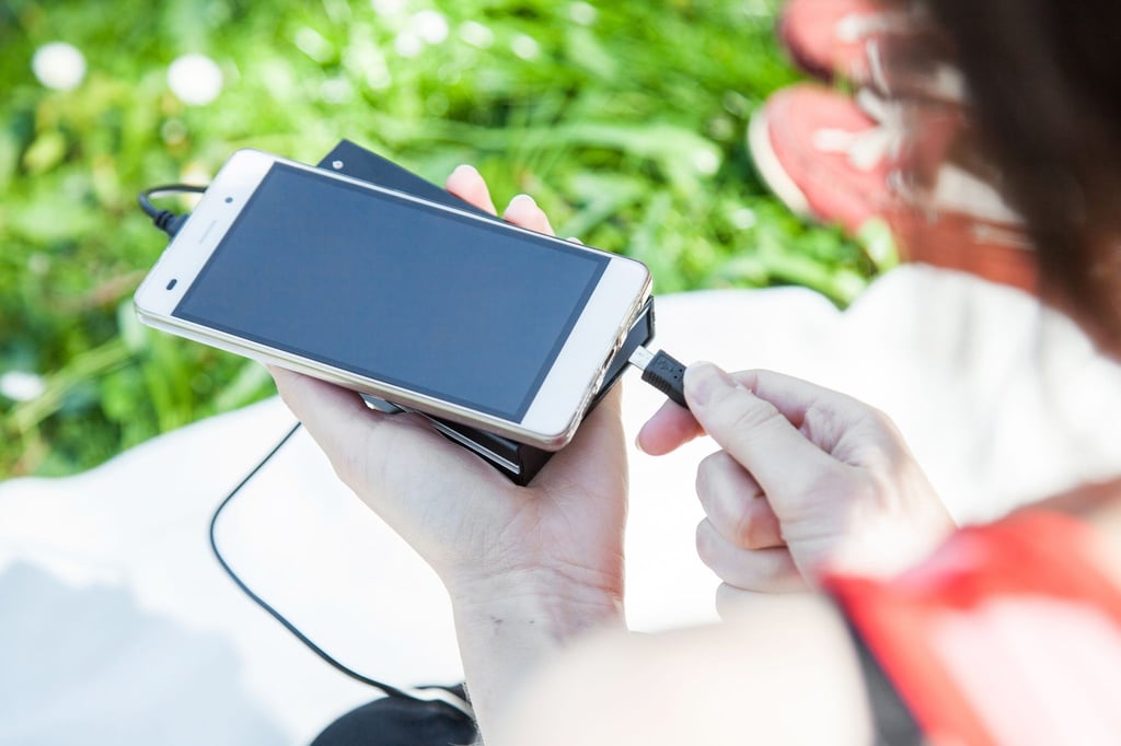 Frische Luft und warmer Sonnenschein: Während vielleicht ein Eis die Besitzerin erfrischen könnte, freut sich das leere Handy über Energie aus der Powerbank - doch zu heiß sollte es nicht werden.