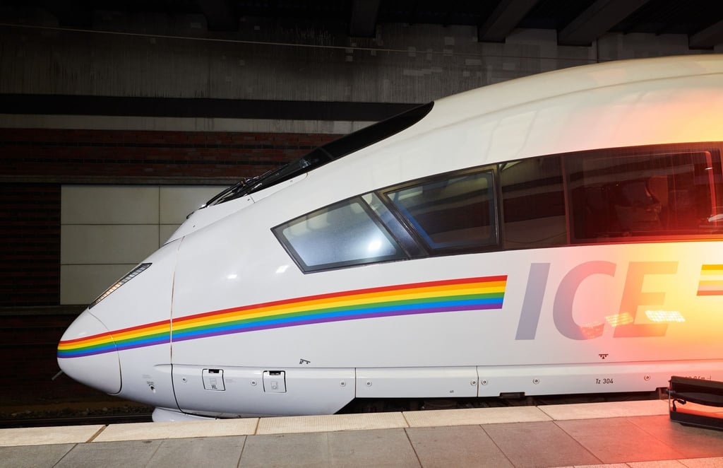 Ein ICE ist mit einem Streifen Regenbogenfarben lackiert.
