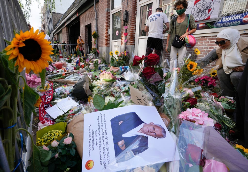 Menschen haben Bilder des Kriminalreporters und Blumen am Tatort niedergelegt.