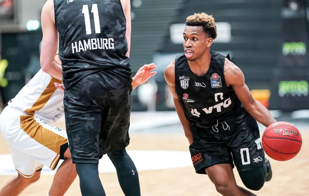 Hamburgs Guard TJ Shorts (r) dribbelt am Block seines Mannschaftskameraden Maik Kotsar vorbei.