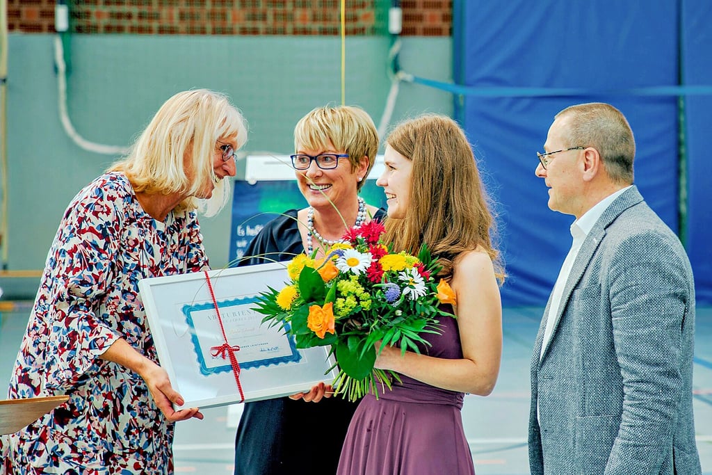 Die schulfachliche Koordinatorin Kerstin Hädrich (links) und Anke Hustedt sowie Schulleiter Bernd Malkowski zeichnen Paula Schmidt als Abiturientin des Jahres aus.