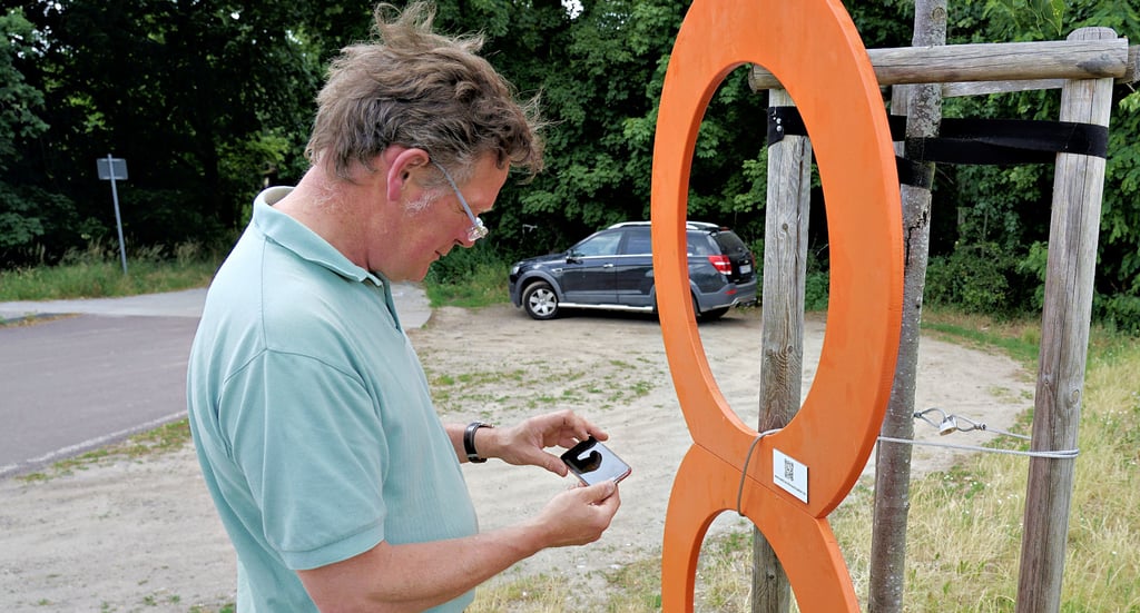 Enno von Katte überprüft den Sitz der orangenen Acht nach dem Aufstellen an der Roßdorfer Kanalbrücke.