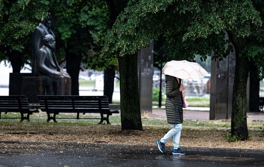 Eine Passantin geht bei Regen durch Berlin-Mitte.